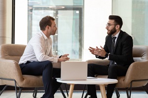 businessmen seated on armchair in modern office talking solve common issues