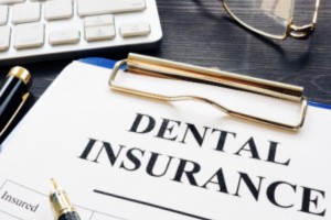 Dental insurance written paper stuck with clipboard