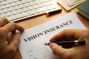Man signing document related to vision insurance