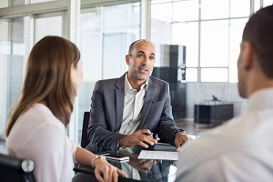 mature financial agent showing new investment to young couple