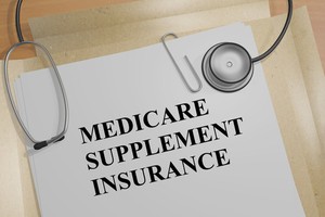 Medicare supplement insurance file placed on table with a stethoscope