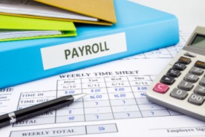 Payroll management documents and a calculator