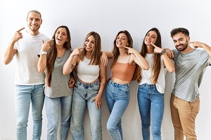 young friends standing together over isolated background smiling with their group dental benefits