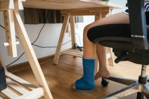 person at work with a leg cast
