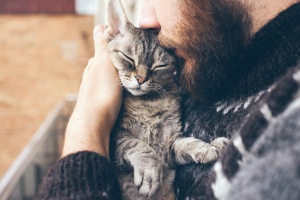 man kissing his cat with pet insurance 