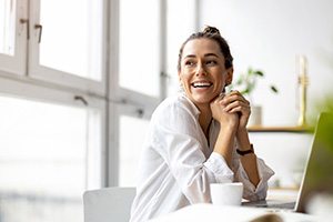 Woman smiling while working on her laptop