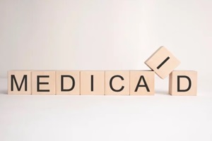 word medicaid is written on wooden cubes on a light background
