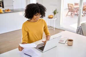 woman smiling at rebate on laptop