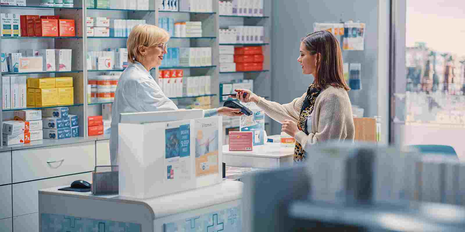 Pharmacist helping young women check out medicine