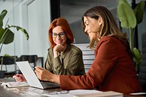 two employees reviewing time sheets on computer