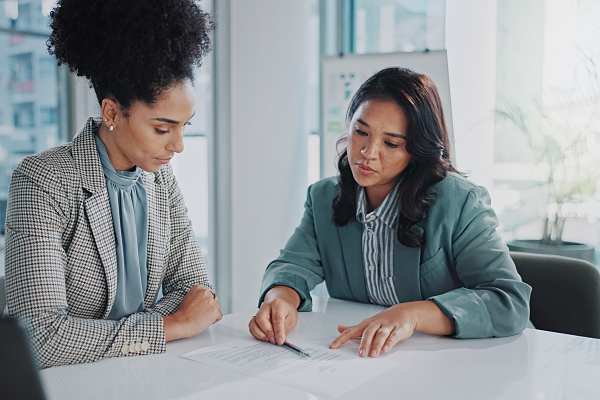 two women reviewing employee benefits documents