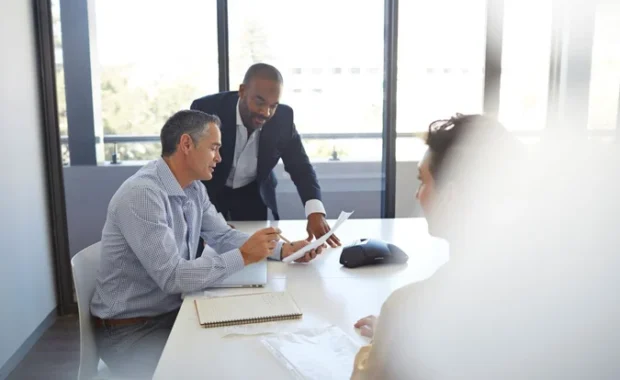 Businesspeople-Reviewing-Paperwork-in-ConferenceRoom-1200-800