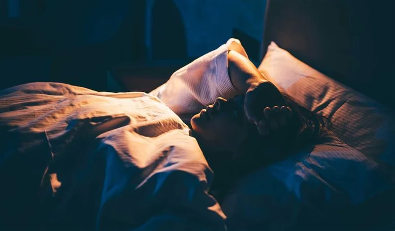 Woman-with-Insomnia.-Young-woman-lying-on-bed-with-hand-on-forehead