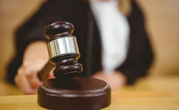 Hand about to bang gavel on sounding block in the court room