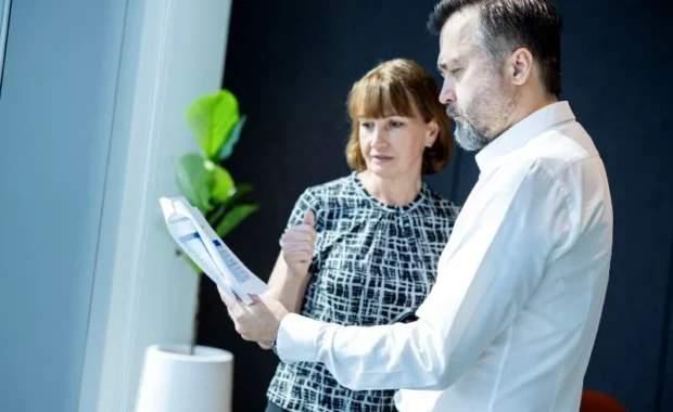 Man-and-Woman-Standing-in-Office-Reviewing-Paperwork-800-533